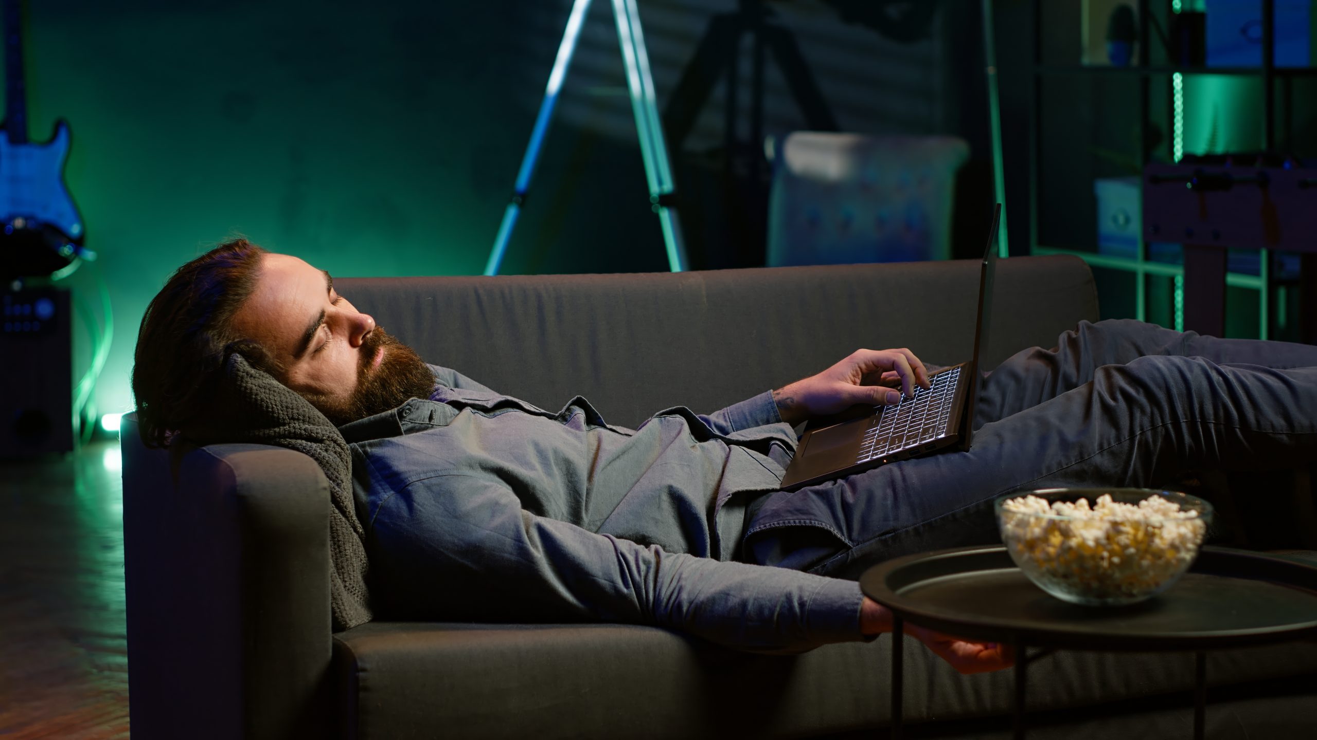 Homme endormi devant son ordinateur portable après avoir regardé une vidéo trop longue