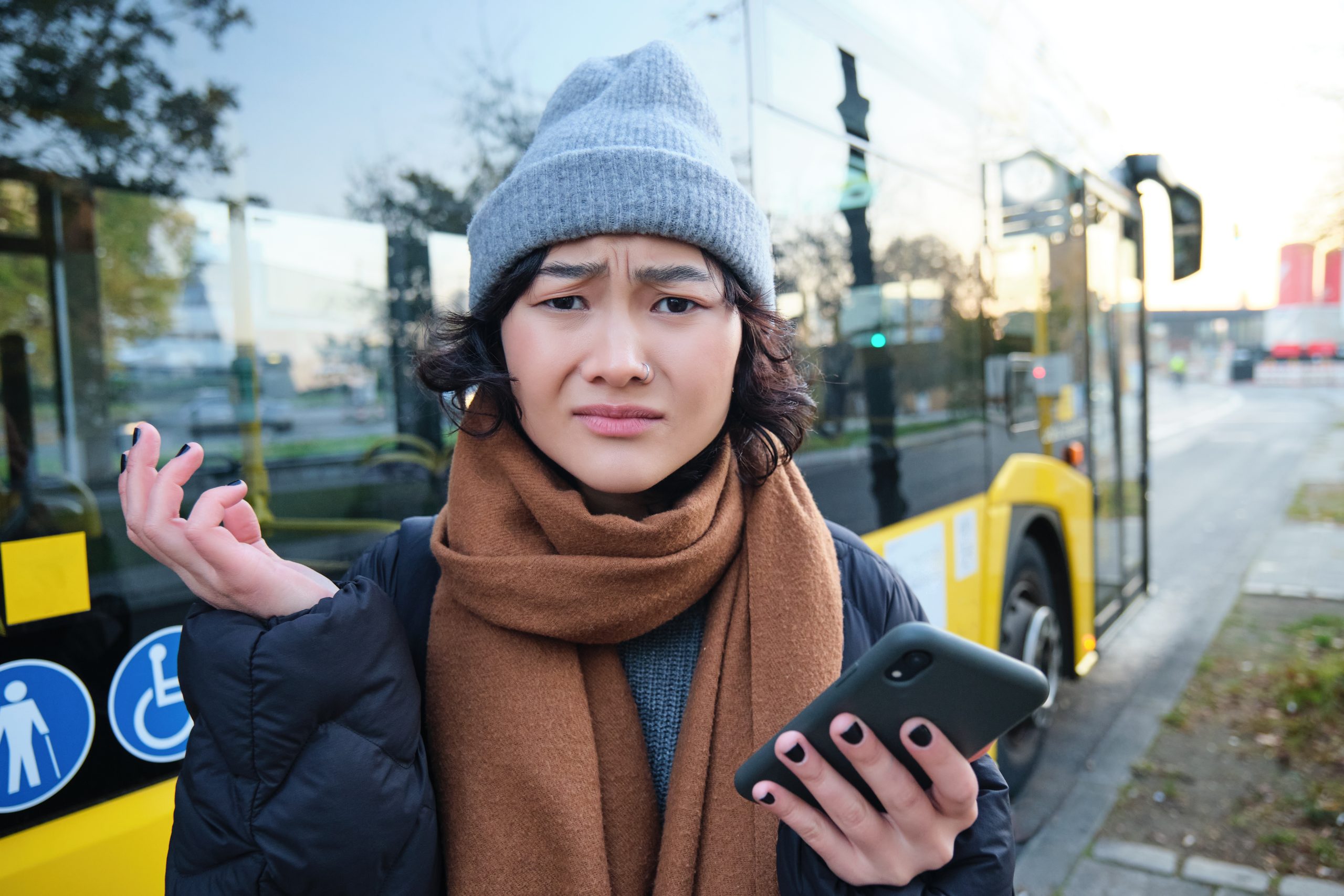 Femme confuse tenant son smartphone, symbolisant la frustration de quitter une vidéo trop tôt